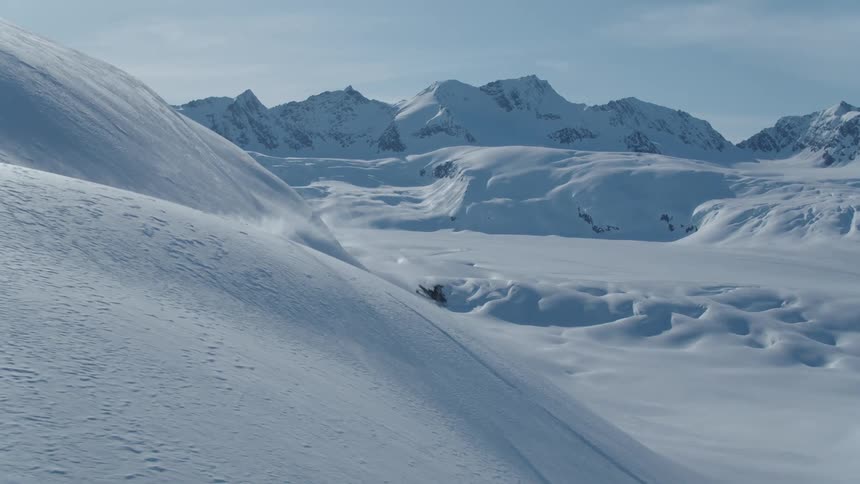 Person on a snowmobile jumping off a mountain