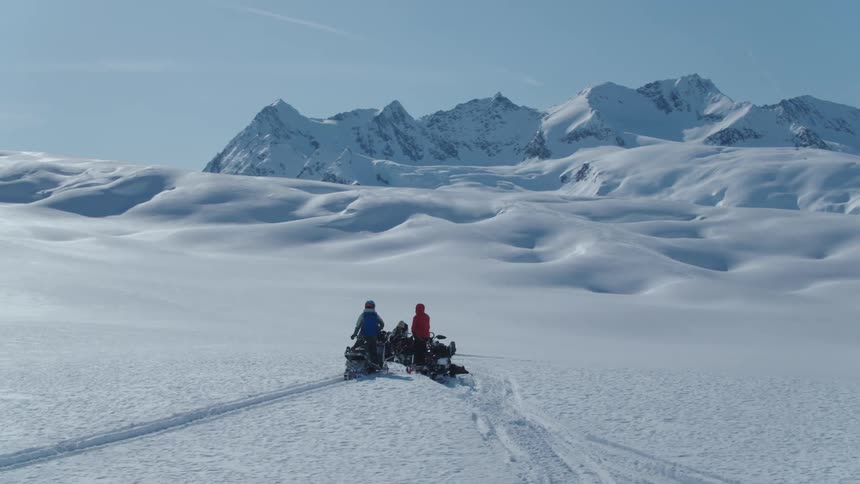 Four people on a snowmobile in an arctic location