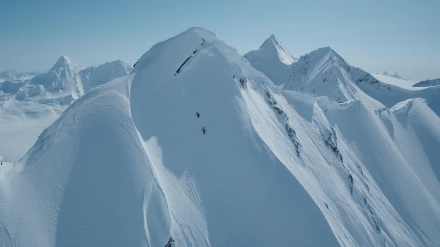 Aerial view of two people climbing a steep snowcovered mountain