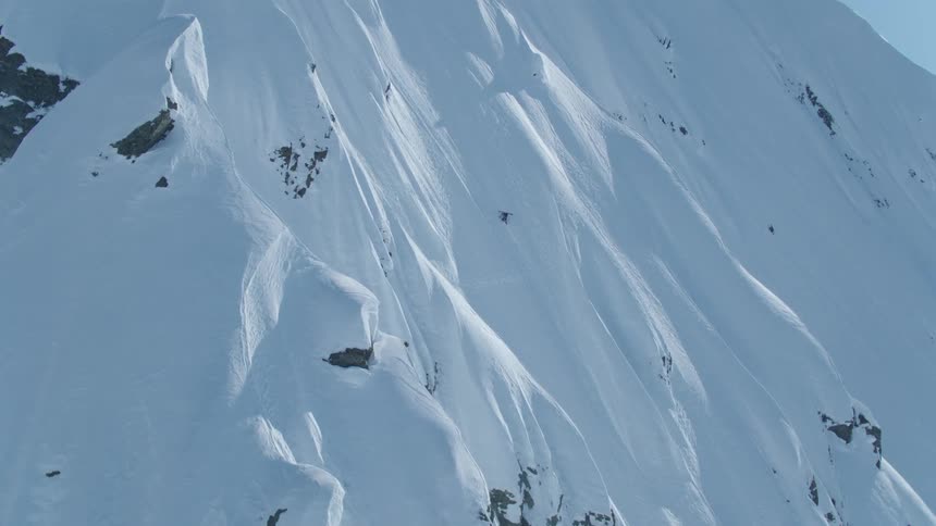 Two skiers carve their way up a steep snowcovered slope leaving behind a trail of powdery snow