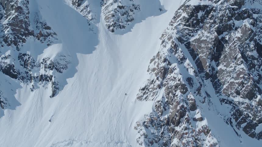 A person climbing the snow covered slopes of a mountain to reach the summit
