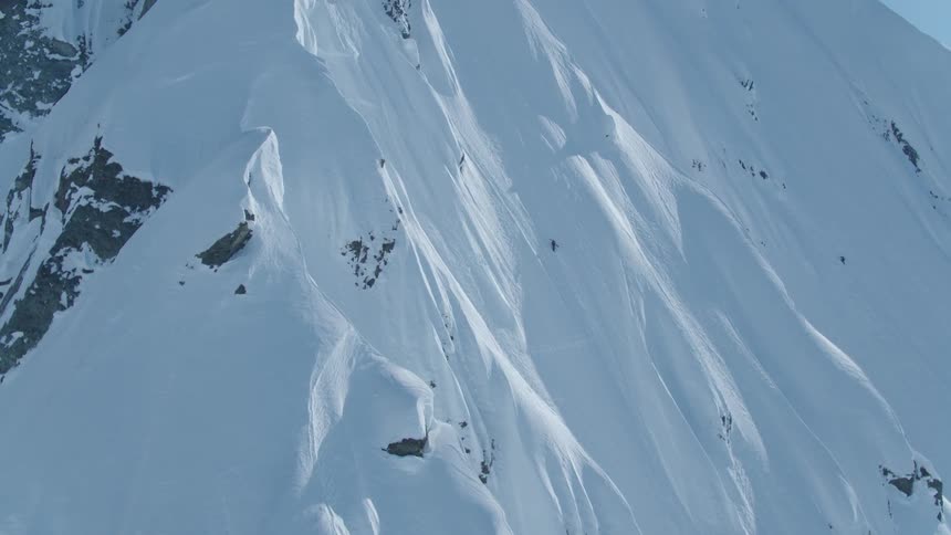 Isolated person climbing a snowy mountain wall