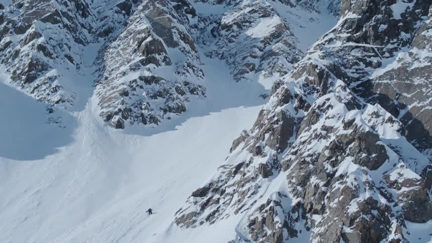 Lone person climbing a snowy mountain