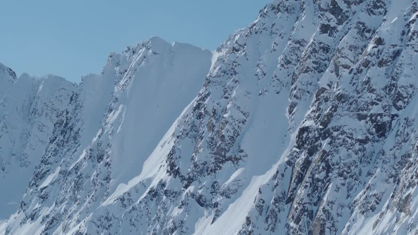 Aerial of a snowcovered mountain range on a sunny winter day