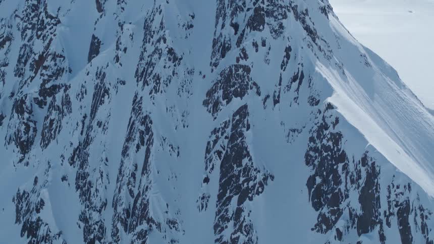 Snowcapped mountain with rocky outcrops and steep slopes