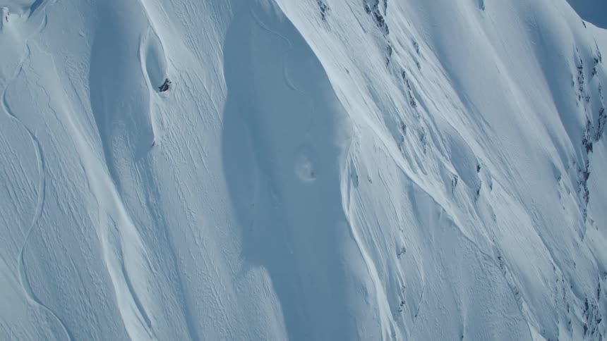 Aerial of an extreme skier skiing down the summit of a mountain