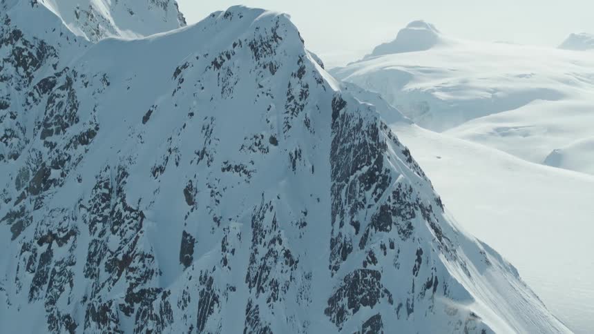 Aerial view of a person skiing down a large snowy mountain
