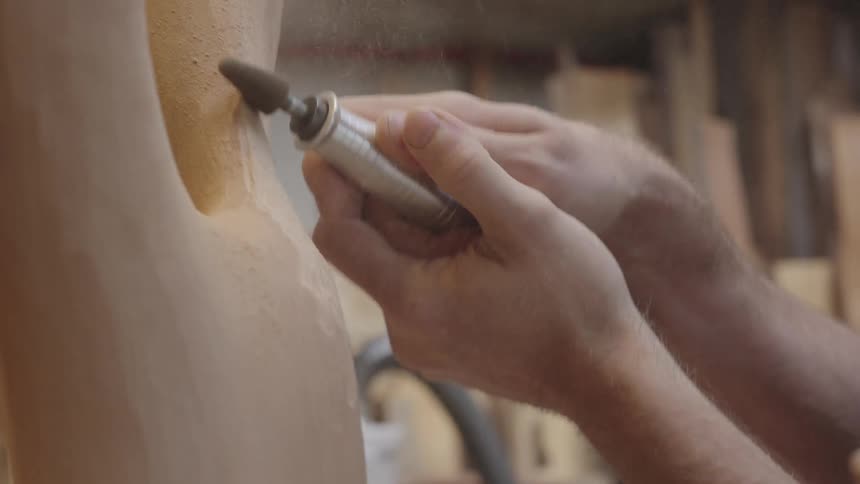 Closeup of hands working on a wooden object