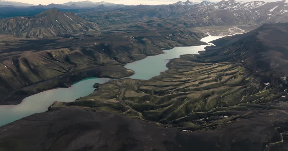 Aerial view of a rugged landscape with lakes between hills