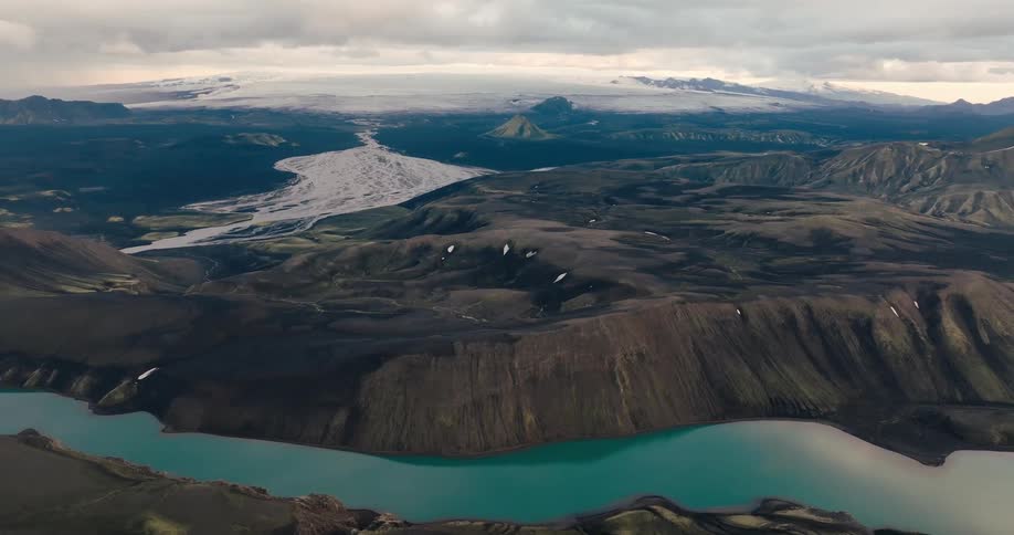A glacial lake nestled between rugged volcanic mountains