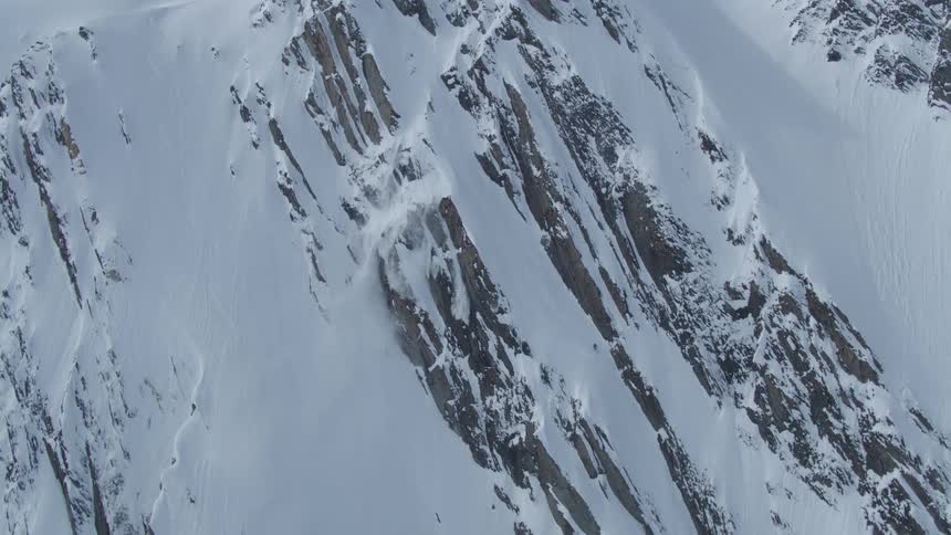 Aerial view of a person skiing down a snowy mountain at high speed