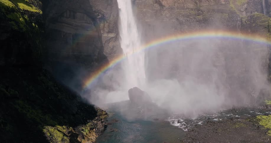 Double rainbow under a rapidly cascading waterfall in the canyon