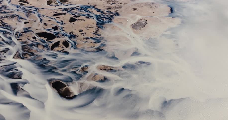 Aerial view of a landscape that mixes water and sand formations creating an abstract and natural pattern