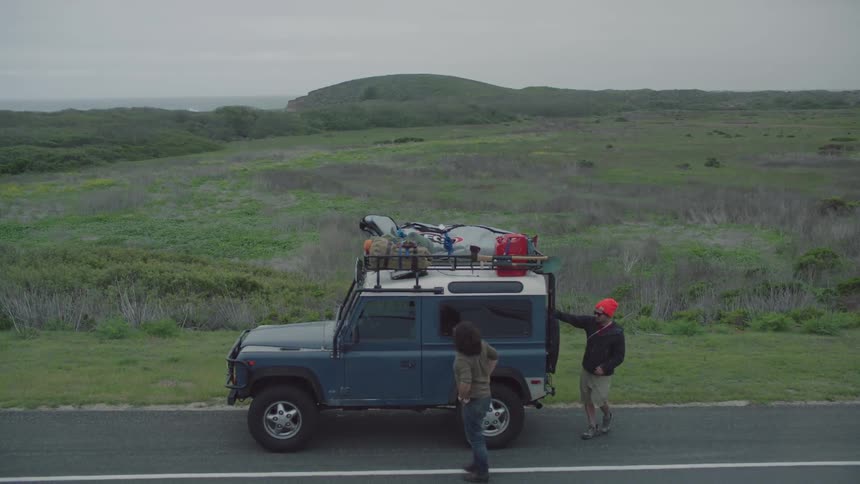 Two men get out of their jeep on the side of the road