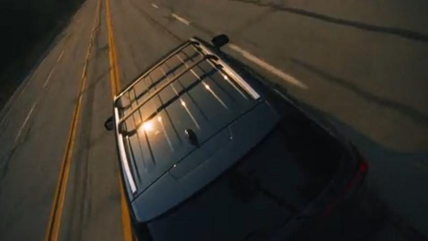 SUV races away toward mountains beyond