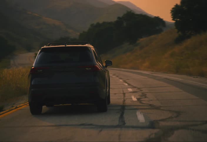 Camera follows black SUV and booms up