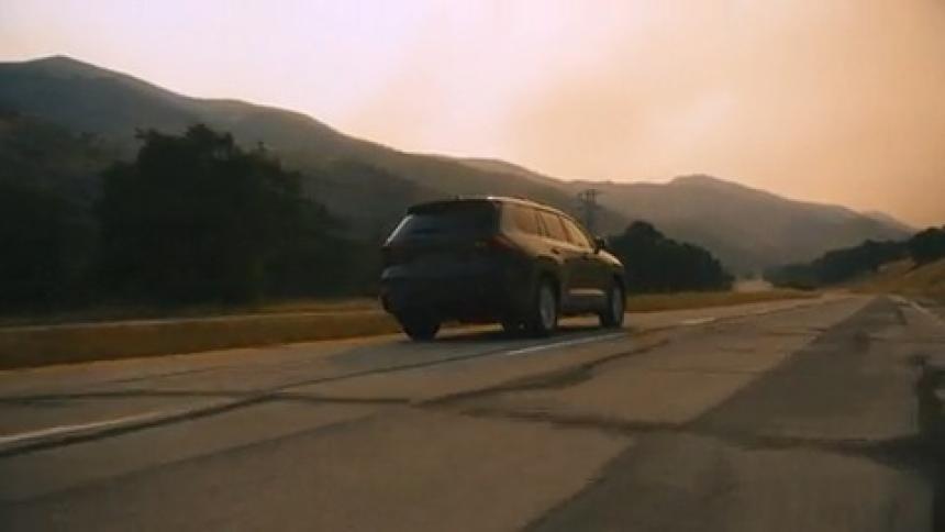 Black suv car traveling on a road surrounded by mountains