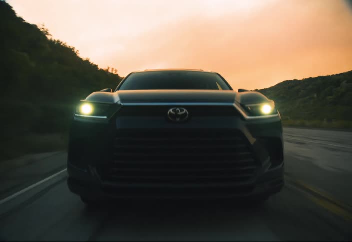 SUV charges toward camera with headlights on