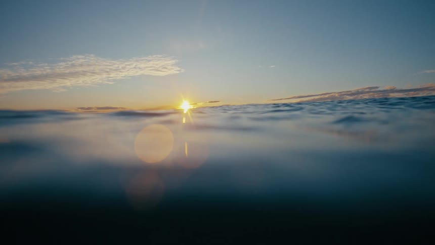 Landscape from within the sea with calm waters and the sun on the horizon