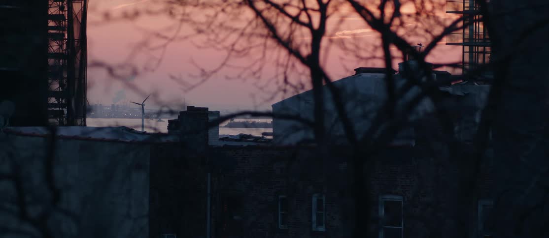 Landscape of nyc metropolis with the sea in the background and the reddish sky wind turbine