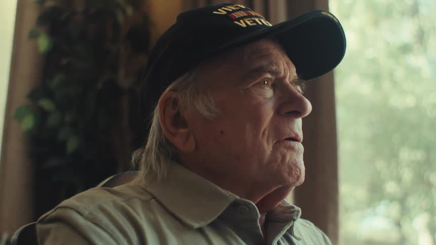 Elderly man sitting at the table thoughtfully and begins to write