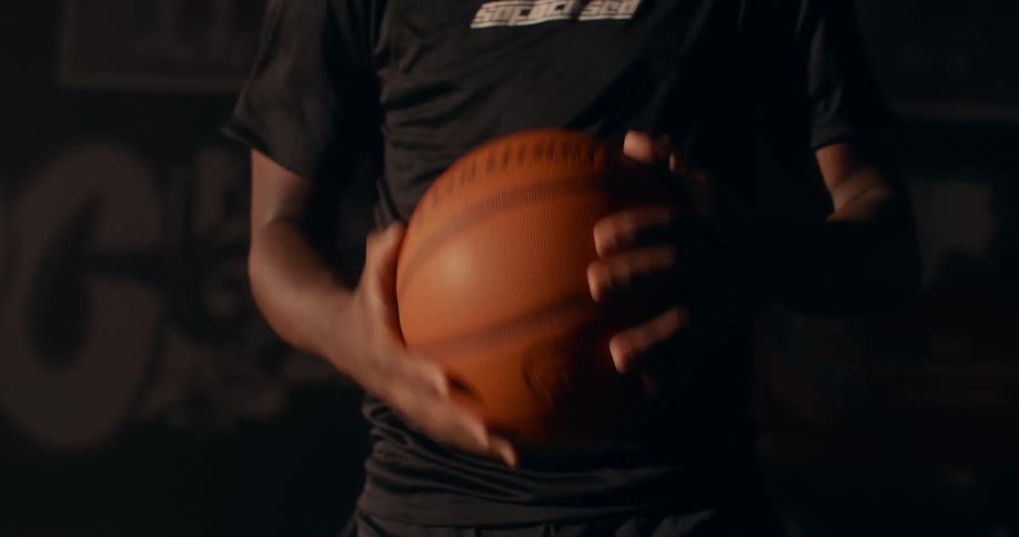 A man slams a basketball between his hands