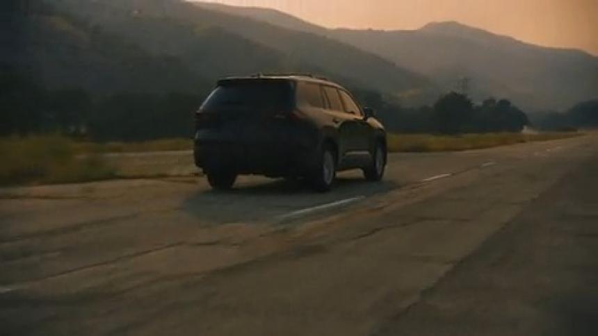 Black SUV driving into distant mountains