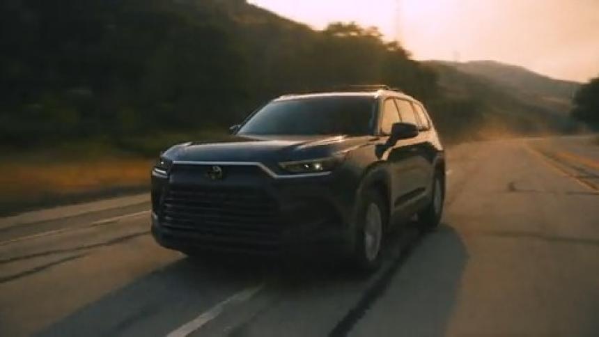 Black car changes lanes on country road at sunrise