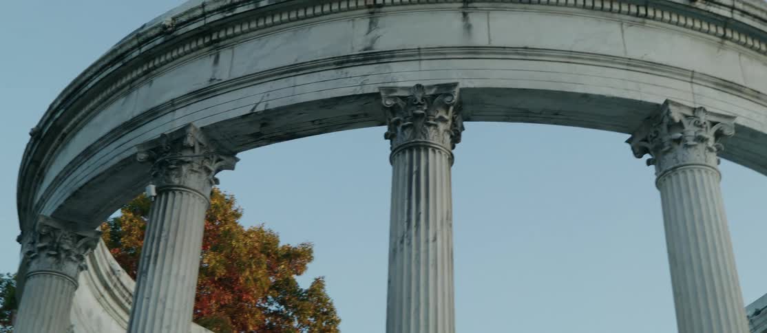 A circular neoclassical structure with tall white columns against a blue sky
