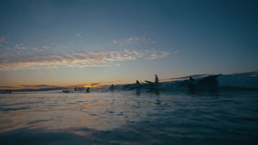 Scenery at dawn with surfers in the ocean