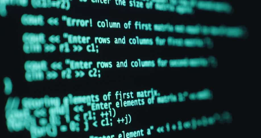 A closeup of a computer screen displaying code or programming language on a black background