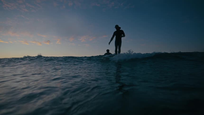 A person rides a wave on a surfboard