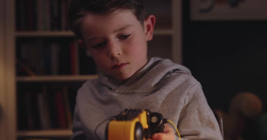 Boy with a screwdriver working on a robotic arm