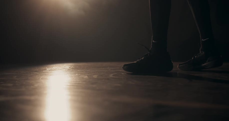 Person lifting a basketball with their feet