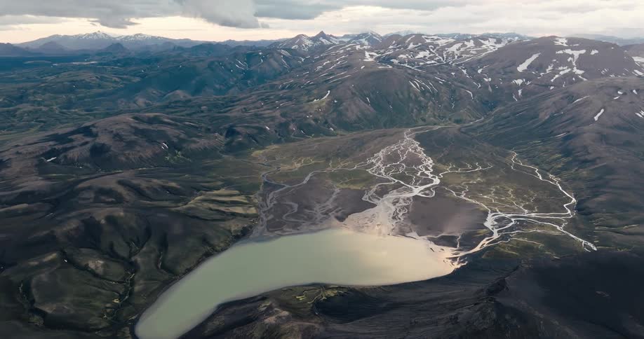 Aerial landscape of a lake on a plateau surrounded by snowy mountains