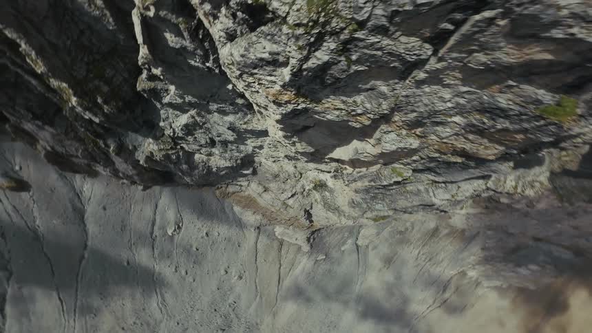 FPV Dive Down a Large Rocky Mountain Range into a Green Valley in Switzerland