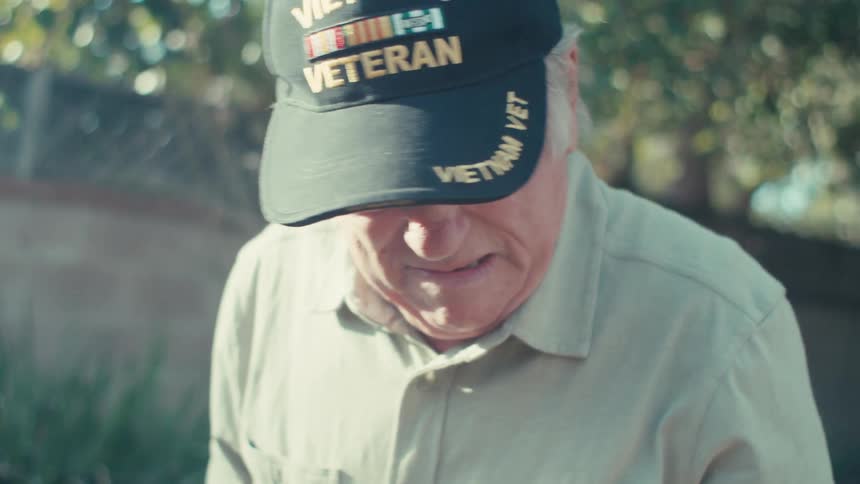 Elderly veteran works in his garden on a sunny day