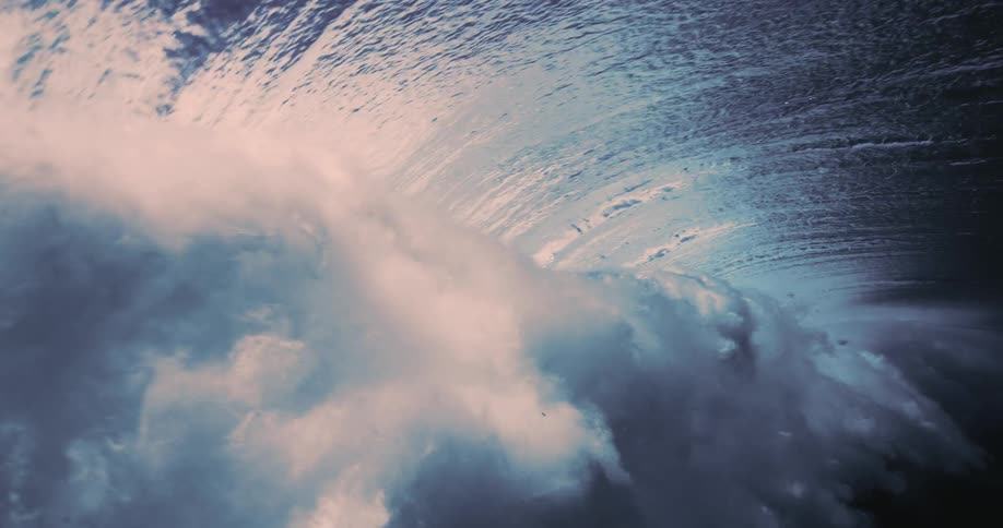 A giant wave breaks on a coast seen from underneath the water
