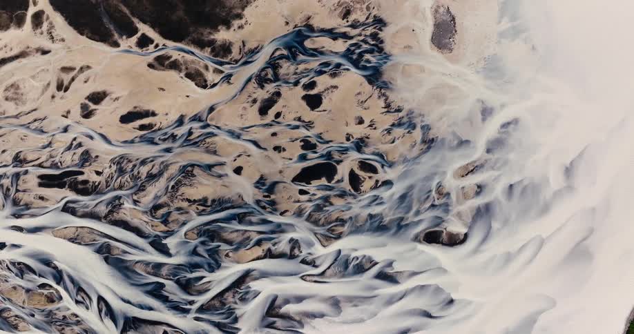 Aerial view of a winding river flowing through a barren desertlike landscape