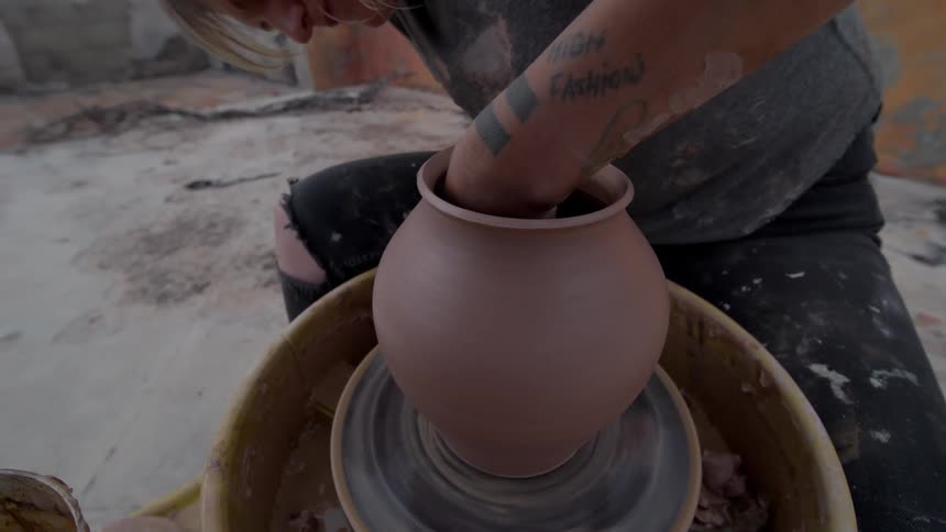 Woman molding a clay vase