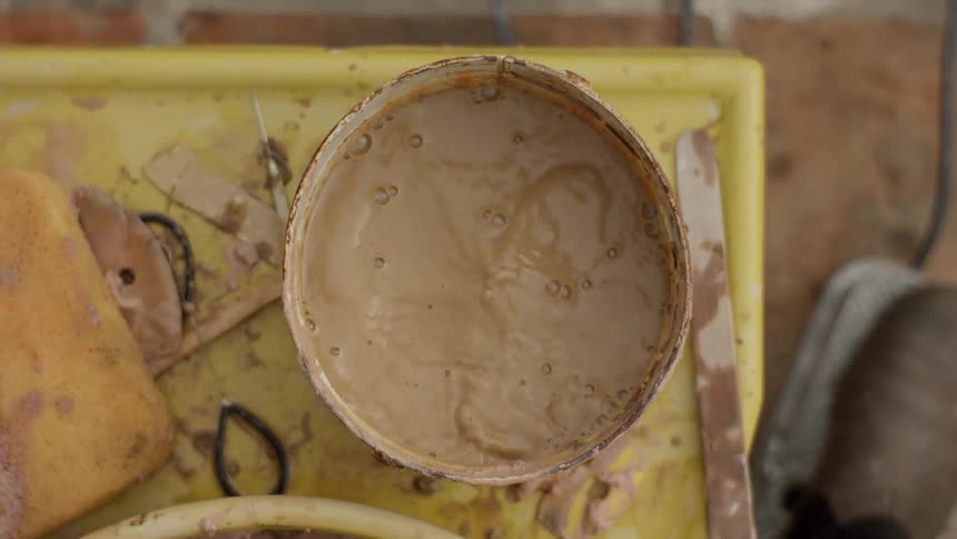 Womans hand in contact with water with clay in a bucket