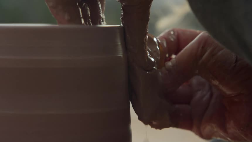 A person is sculpting a vase