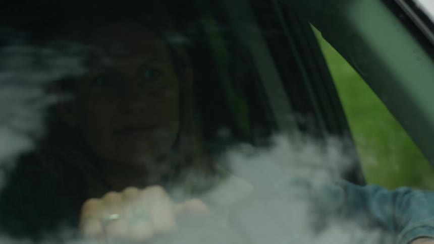 A woman is driving a car during the day