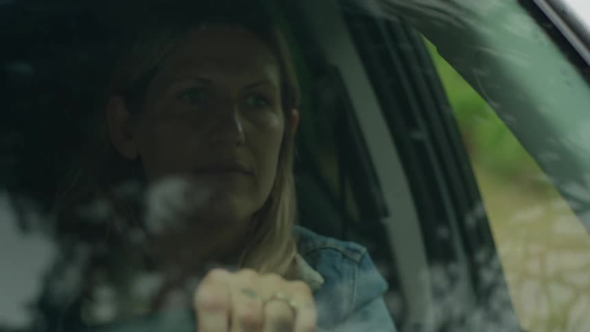 Closeup of a blonde woman driving a car on a summer day