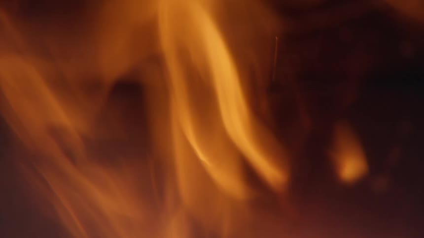 Flames burn against a textured background during the night