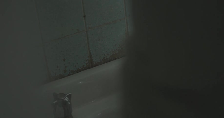 A person turns on a bathroom faucet and washes their hands