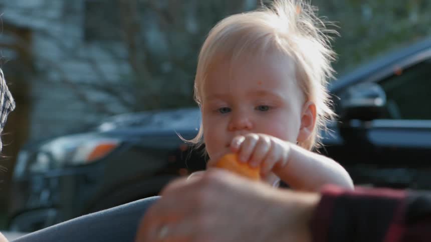 Little boy taking a piece of pumpkin given to him by his parents