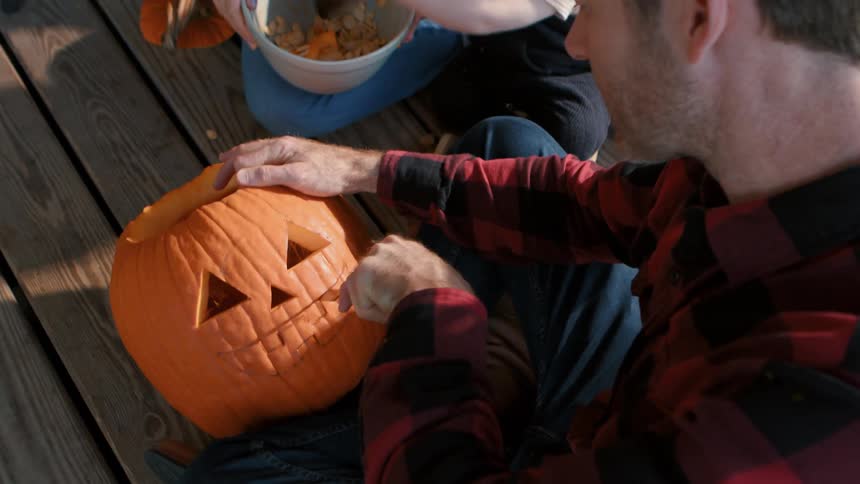 A family carve a pumpkin together