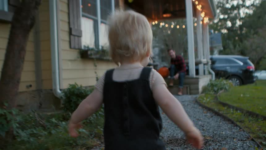 Little blonde boy walking toward his father