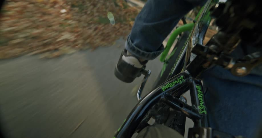 Closeup of a boy riding a bicycle down the sidewalk